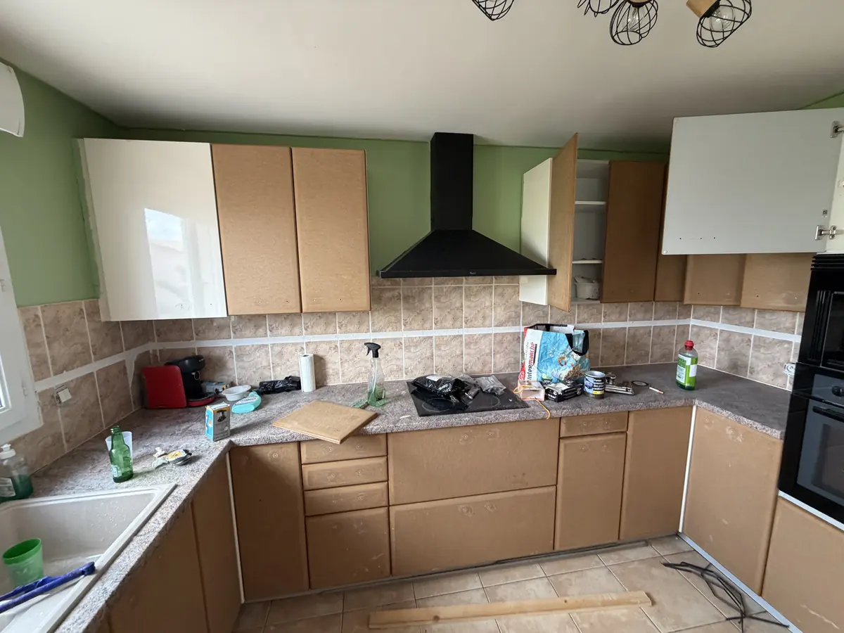 Cuisine avant travaux, murs verts et meubles datés